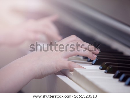 A child plays a white digital piano. Photo with selective focus