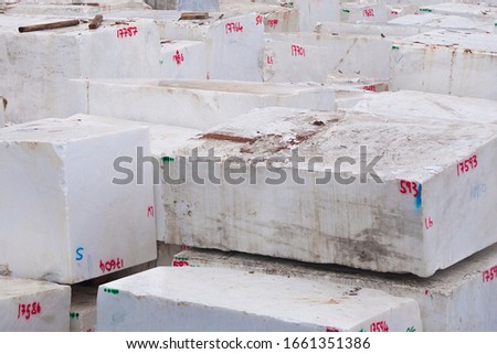 Raw italian marble blocks stocked in the Carrara harbor ready to be shipped
