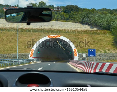 Entrance of a tunnel seen from a car during a drive