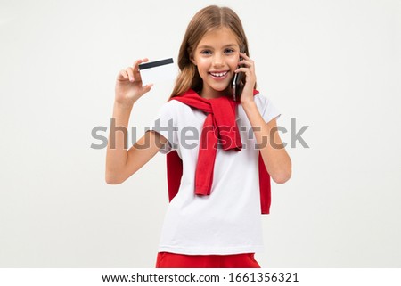 Cute teenager with beautiful face holds a credit card, picture isolated on white background