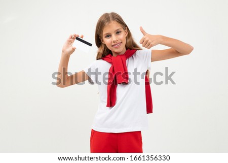 Cute teenager with beautiful face holds a credit card, picture isolated on white background