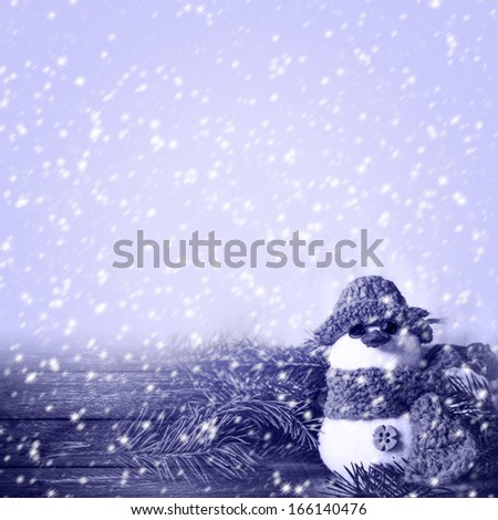 Snowman on a wooden background in winter weather