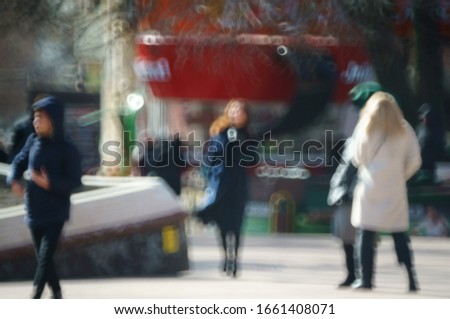 Blurred background. People walk along the street of the city. City life. The movement of the crowd. Silhouettes of people. Family holiday.