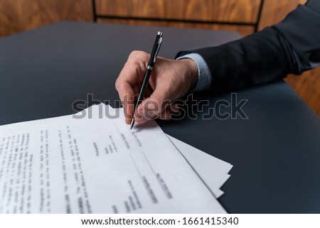 A man signing contract at the office. The concept of entering into partnership.