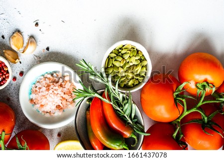 Organic food frame with spices and vegetables on stone background with copy space