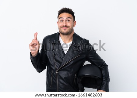 Man with a motorcycle helmet with fingers crossing and wishing the best