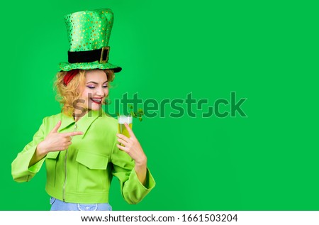 St Patricks Day. Green top hat. Saint Patrick's Day. Woman in top hat drink green beer. Leprechaun. Green beer. Green hat with clover. Irish Traditions. Pub. Woman drinking in pub. Royalty-Free Stock Photo #1661503204