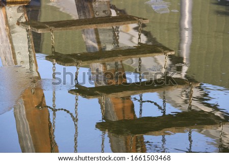 Mirroring of a chain ladder in the water.