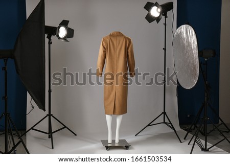 Stylish clothes on ghost mannequin and professional lighting equipment in modern studio. Fashion photography Royalty-Free Stock Photo #1661503534