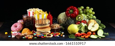 healthy or unhealthy food. Concept photo of healthy and unhealthy food. Fruits and vegetables vs donuts,sweets and burgers on table