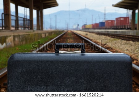Suitcase on the railroad, concept of traveling with the train