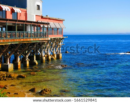 Restaurants and a rocky beach at Cannery Row, in Monterey bay, California. Historic 700 Cannery Row Mall, Beach, Monterey. Royalty-Free Stock Photo #1661529841