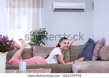 woman using remote control of aircondition