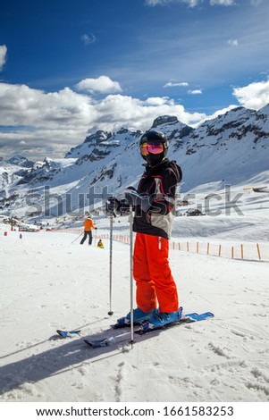 A young skier on mountain resort in sunny day, Italy