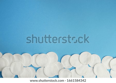 Hygiene cotton pads on blue background top view copyspace