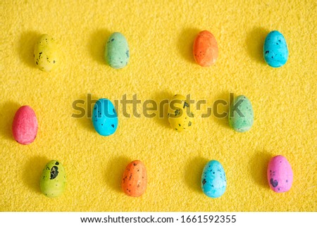 Easter pattern.Bright beautiful egg with a picture for Easter.Multi-colored eggs on a yellow fluffy background. Easter card.