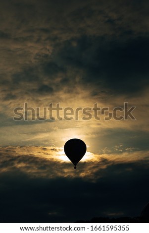 hot air balloon silhouette at sunset. Vertical stock photo. Adventure concept.