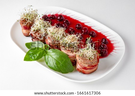 Beef minion in bacon with herbs in berry sauce with potatoes. Banquet festive dishes. Gourmet restaurant menu. White background.