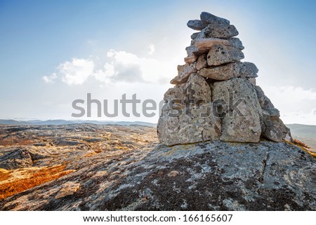 Stone cairn as a navigation mark on the top of Norwegian mountain Royalty-Free Stock Photo #166165607