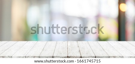 Empty wood table top and blurred of window interior restaurant banner mock up abstract background - can used for display or montage your products.