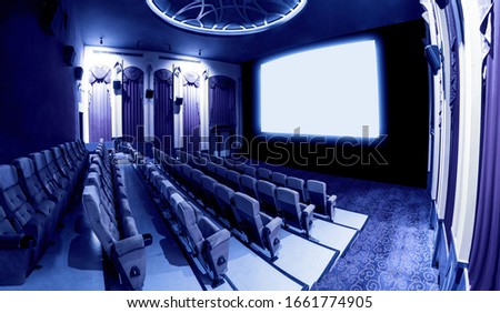 Cinema theater screen in front of seat rows in movie theater showing white screen projected from cinematograph. The cinema theater is decorated in classical style for luxury feeling of movie watching. Royalty-Free Stock Photo #1661774905