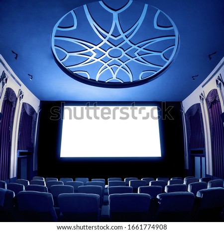 Cinema theater screen in front of seat rows in movie theater showing white screen projected from cinematograph. The cinema theater is decorated in classical style for luxury feeling of movie watching. Royalty-Free Stock Photo #1661774908