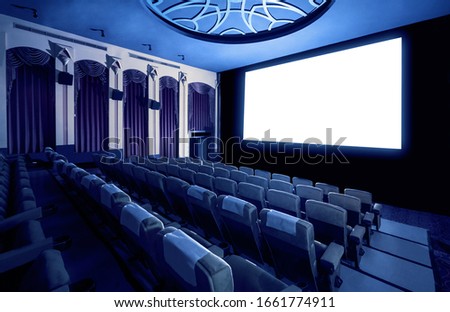 Cinema theater screen in front of seat rows in movie theater showing white screen projected from cinematograph. The cinema theater is decorated in classical style for luxury feeling of movie watching. Royalty-Free Stock Photo #1661774911