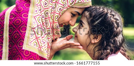 Portrait of religious enjoy happy love asian family arabic muslim mother and little muslim girls child with hijab dress smiling and having fun touching face with cute kid daughter moments good time