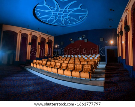 Large cinema theater interior with seat rows for audience to sit in movie theater premiere by cinematograph projector. The cinema theater is decorated in classical for luxury feel of movie watching. Royalty-Free Stock Photo #1661777797
