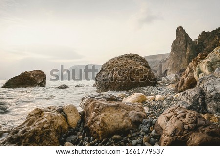 Sunset at the rocky seashore. Black sea. Horizontal layout for travel stories