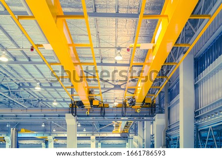 Overhead crane or bridge crane consists of parallel runways with a bridge between column also include hoist lifting and rope.
Machinery for manufacturing or transportation in factory or warehouse.ing. Royalty-Free Stock Photo #1661786593