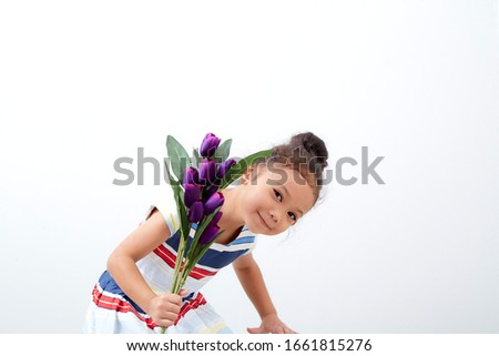 Portrait Happy funny asian cute child girl easter day hand holding  bouquet purple tulip on white background . Happy easter