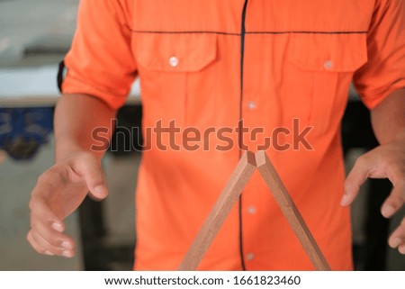 A young carpenter focus concentrate on  wooden plank  balancing . Conceptual image for being success.