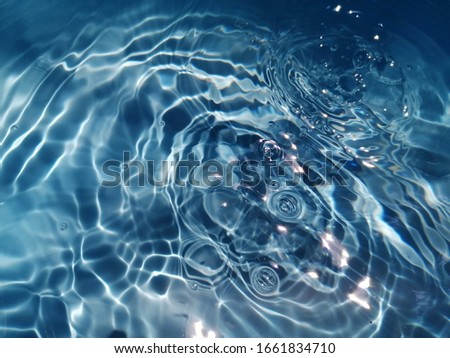 The​ abstract​ of​ surface​ blue​ water​ in​ the​ swimming​ pool​ for​ background. Blue​ water​ splash​ed for​ background​