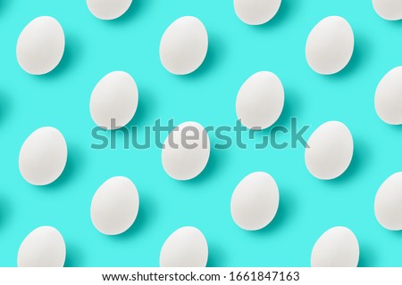 Easter white eggs with shadows on blue background. Pattern, hipster design. Flat lay.