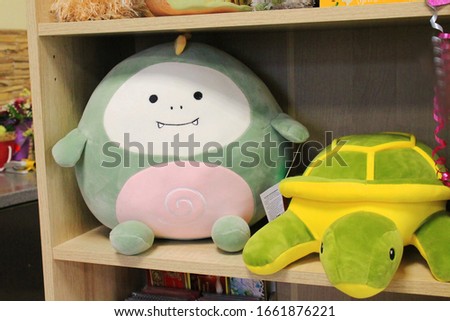 Beautiful soft big toys on a shelf in the store.  Green turtle