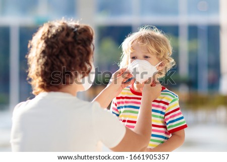 Family with kids in face mask in shopping mall or airport. Mother and child wear facemask during coronavirus and flu outbreak. Virus and illness protection, hand sanitizer in public crowded place. Royalty-Free Stock Photo #1661905357