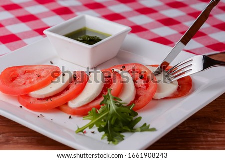 Caprese salad. Healthy meal with tomatoes, feta cheese, spices, fresh basil. Home made, tasty food. Concept for a tasty and healthy vegetarian meal. Copy space banner. Italian concept.