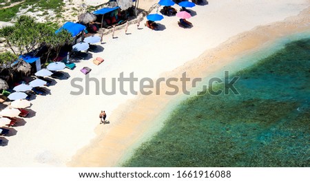 Aerial  top view white sand beach and umbrella and deckchair in a seashore 