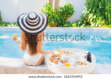 Portrait beautiful young asian woman happy smile with floating breakfast in tray on swimming pool
