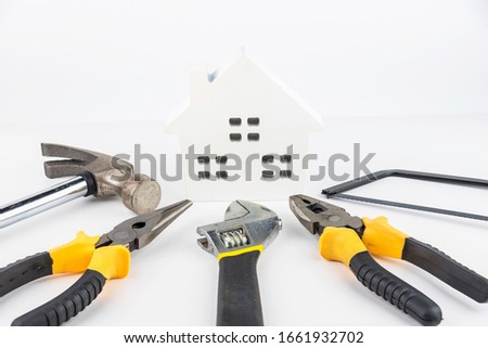 House toy and construction tools on white background with copy space.Real estate concept, New house concept, Finance loan business concept, Repair maintenance concept.