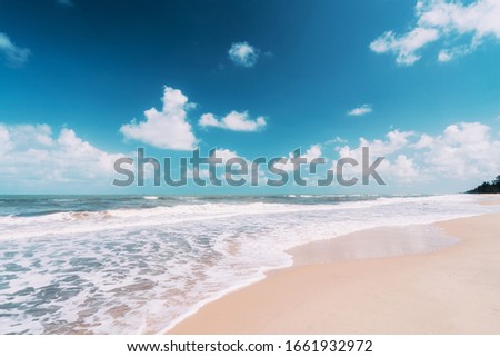 Copy space blur tropical beach with bokeh sun light wave on blue sky and white cloud abstract background. Summer vacation outdoor and travel holiday adventure concept. Vintage tone filter effect color