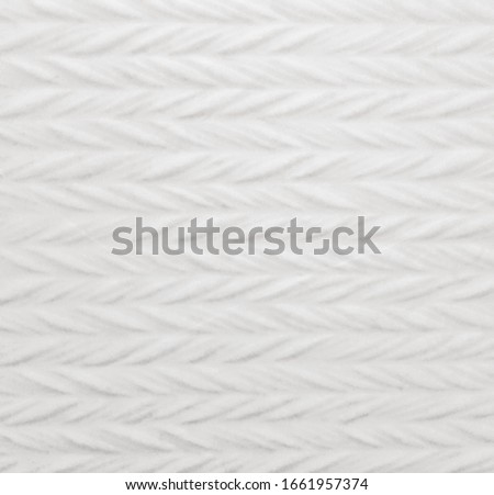 White ceramic tile with abstract braid pattern for wall and floor decoration. Concrete stone surface background. Texture with ornament for interior design project.