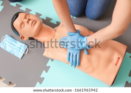 Instructor demonstrating CPR on mannequin at first aid training course Royalty-Free Stock Photo #1661965942