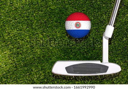 A golf club and a ball with flag Paraguay during a golf game.
