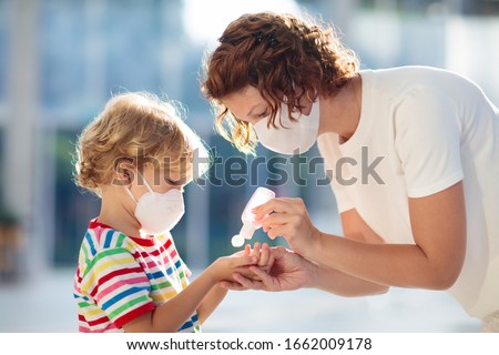 Family with kids in face mask in shopping mall or airport. Mother and child wear facemask during coronavirus and flu outbreak. Virus and illness protection, hand sanitizer in public crowded place. Royalty-Free Stock Photo #1662009178