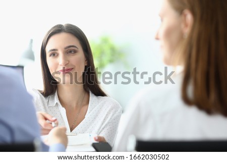 Portrait of smart businesswoman looking at businessman manager with calmness and concentration. Partners discussing important corporation project. Business negotiations concept