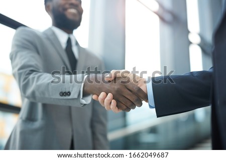 Horizontal close up shot of two unrecognizable modern businessmen shaking their hands, copy space Royalty-Free Stock Photo #1662049687