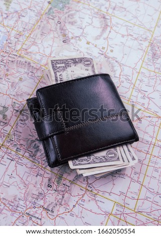 

a map and a wallet with dollar bills