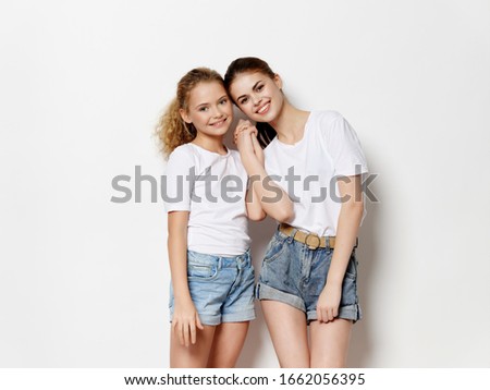 woman hugs little daughter on isolated background